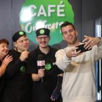 Four people pose together for a selfie in front of the Cafe on George logo. Photo has been taken after the Studio 10 interview finsihes