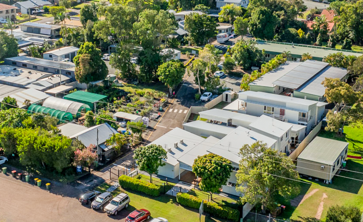 Aerial view of a campus with multiple buildings, trees, and surrounding streets.