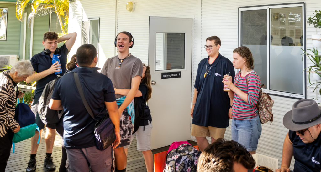 STEPS Pathways College Day College students outside of a training room talking with one another.