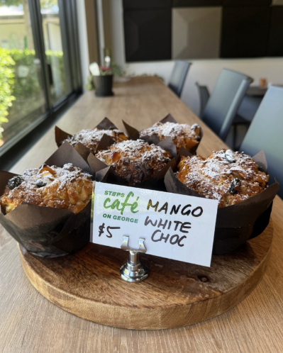 Mango and white chocolate muffins on a wooden plate