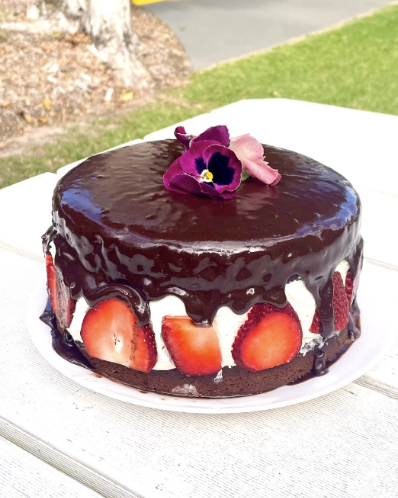 A chocolate strawberry cake on a white plate