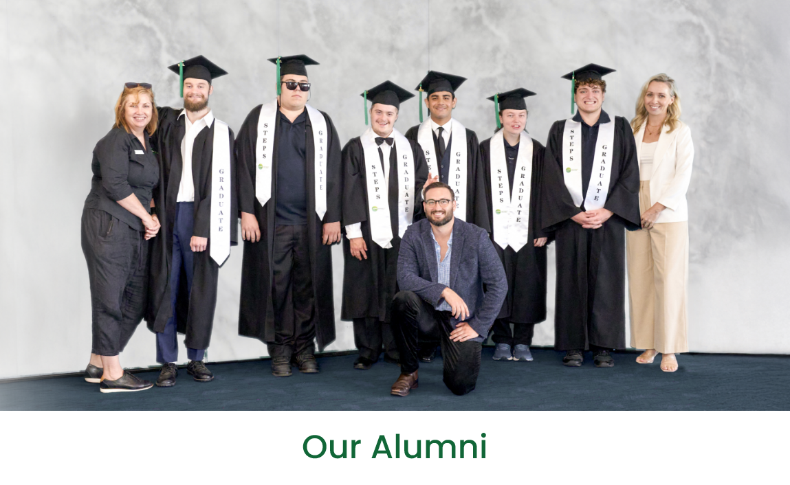 Group of STEPS Pathways College graduates wearing graduation gowns and mortarboards, posing with staff members at a graduation ceremony beneath the heading "Our Alumni".