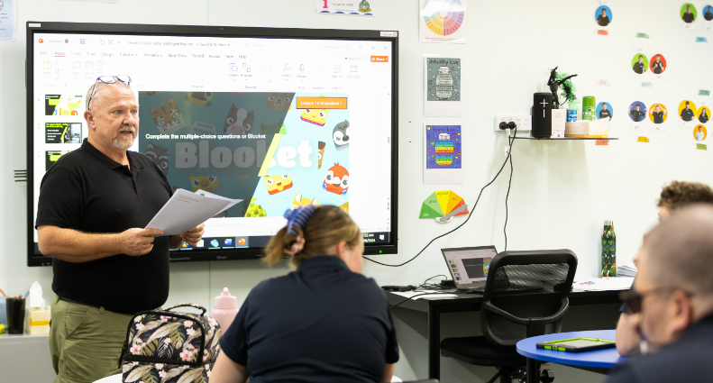 Teacher standing of class presenting to participants of the STEPS Pathways College