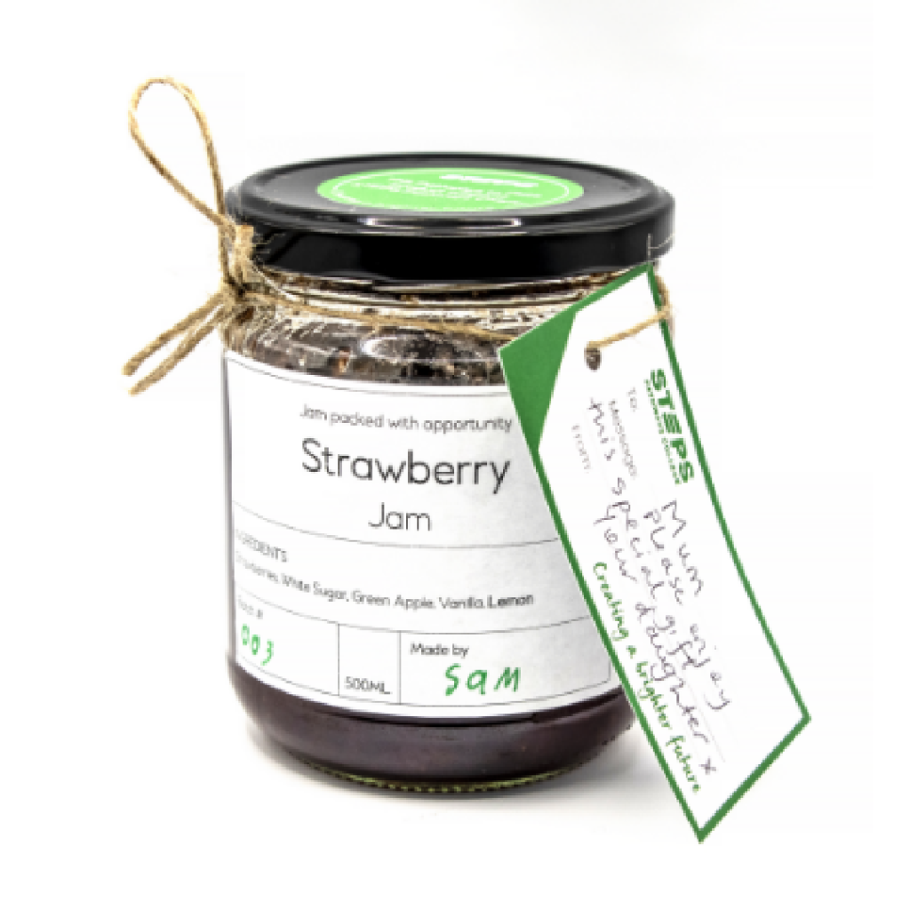 Jar of handmade strawberry jam with a handwritten gift tag and rustic twine, showcasing the Pathways to Plate program.